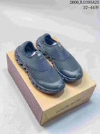 Pair of dark gray KOLON SPORT Galah slip-on shoes on a shoe box.