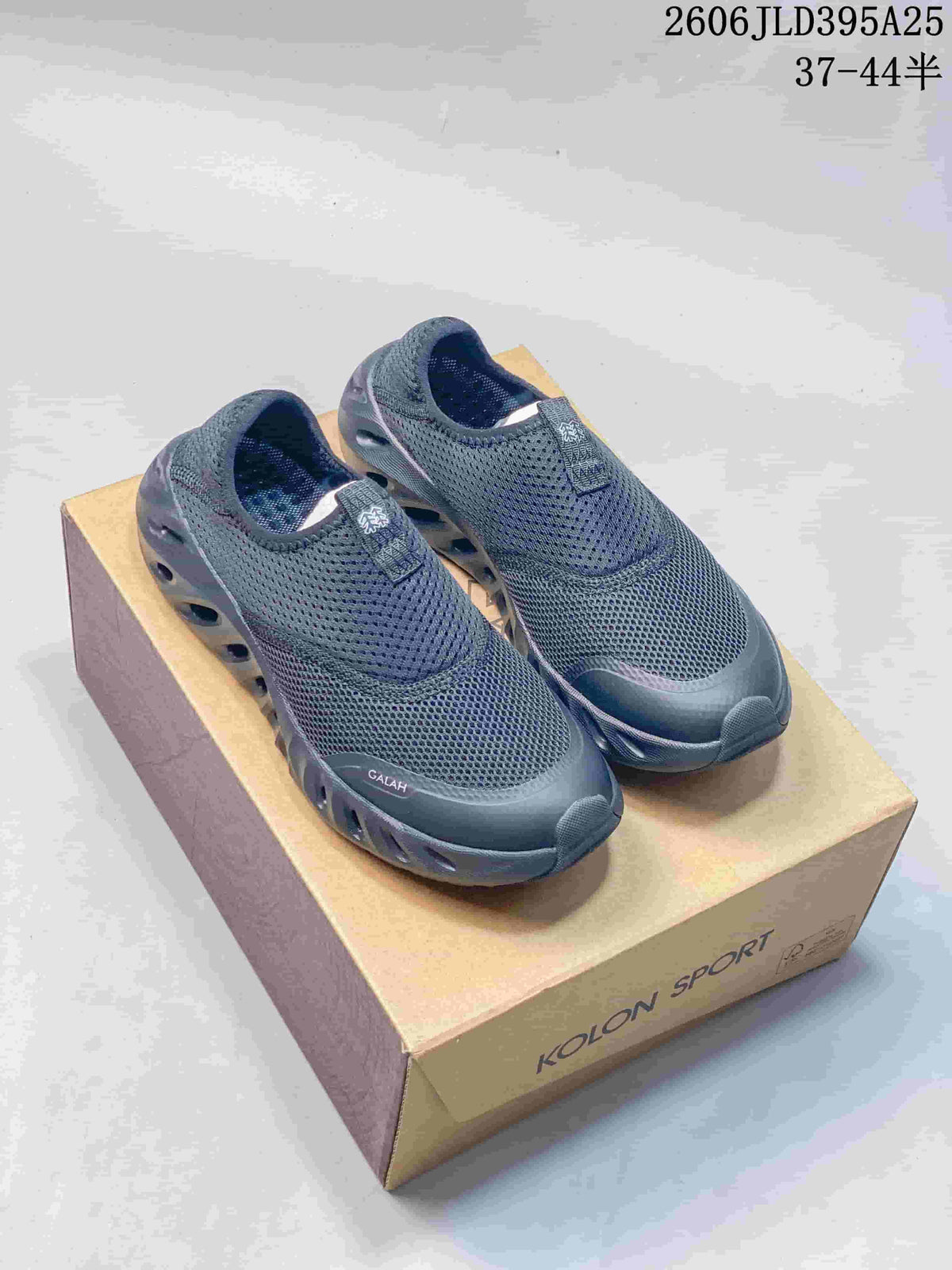 Pair of dark gray KOLON SPORT Galah slip-on shoes on a shoe box.