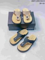 Beige and black sandal color options arranged around a shoebox, showing the toe-post construction and textured footbeds.