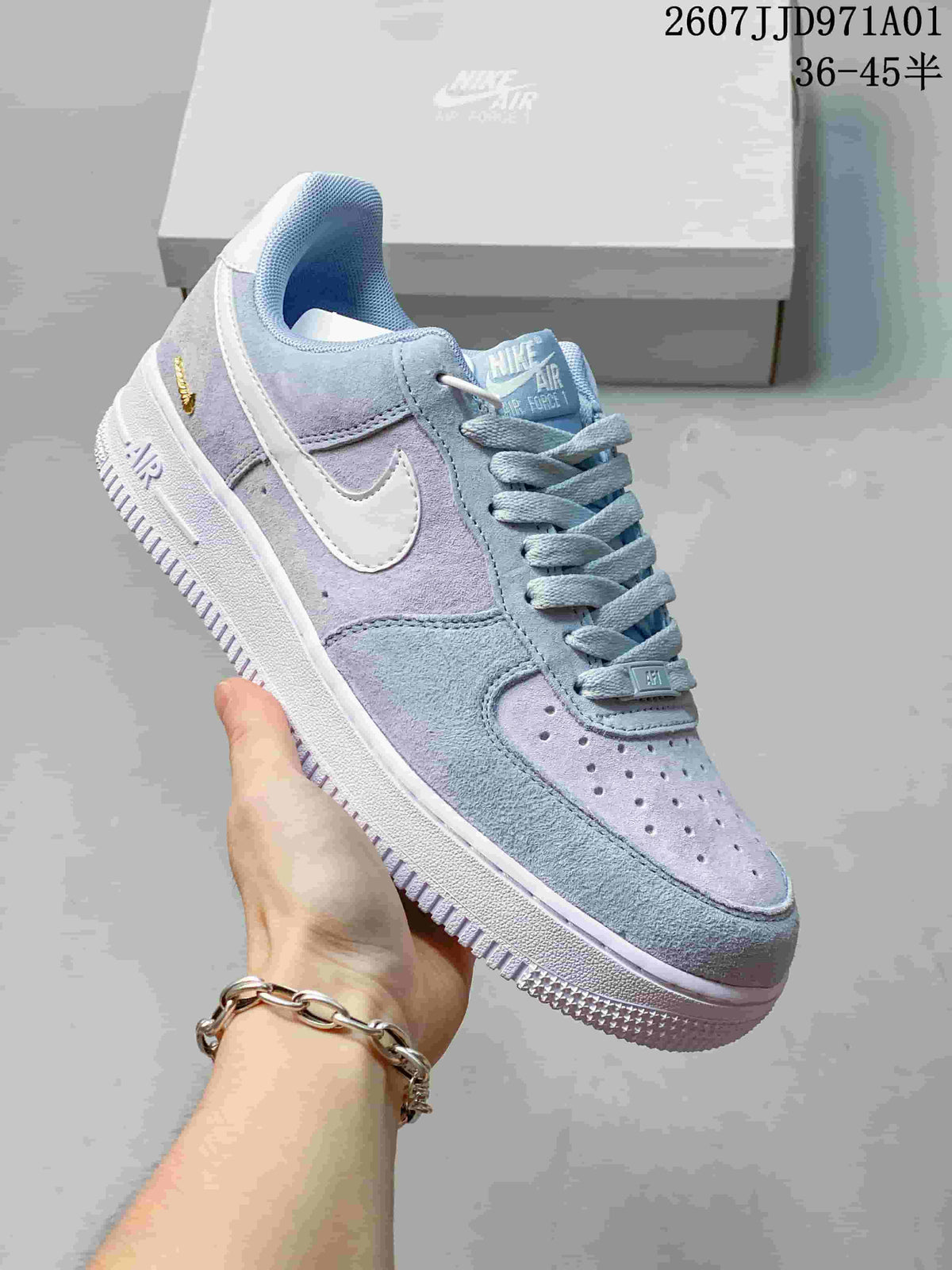 Close view of a pastel blue and lavender Nike Air Force 1 ’07 sneaker, showing the side Swoosh, laces and white sole; printed size range 36–45.