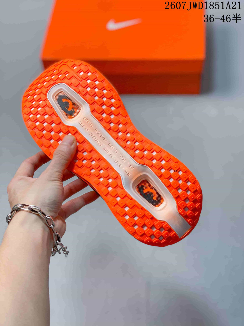 Close view of the orange outsole with textured tread and two visible midsole windows.
