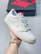 Angled view of the white low-top sneaker with a perforated toe and side logo.
