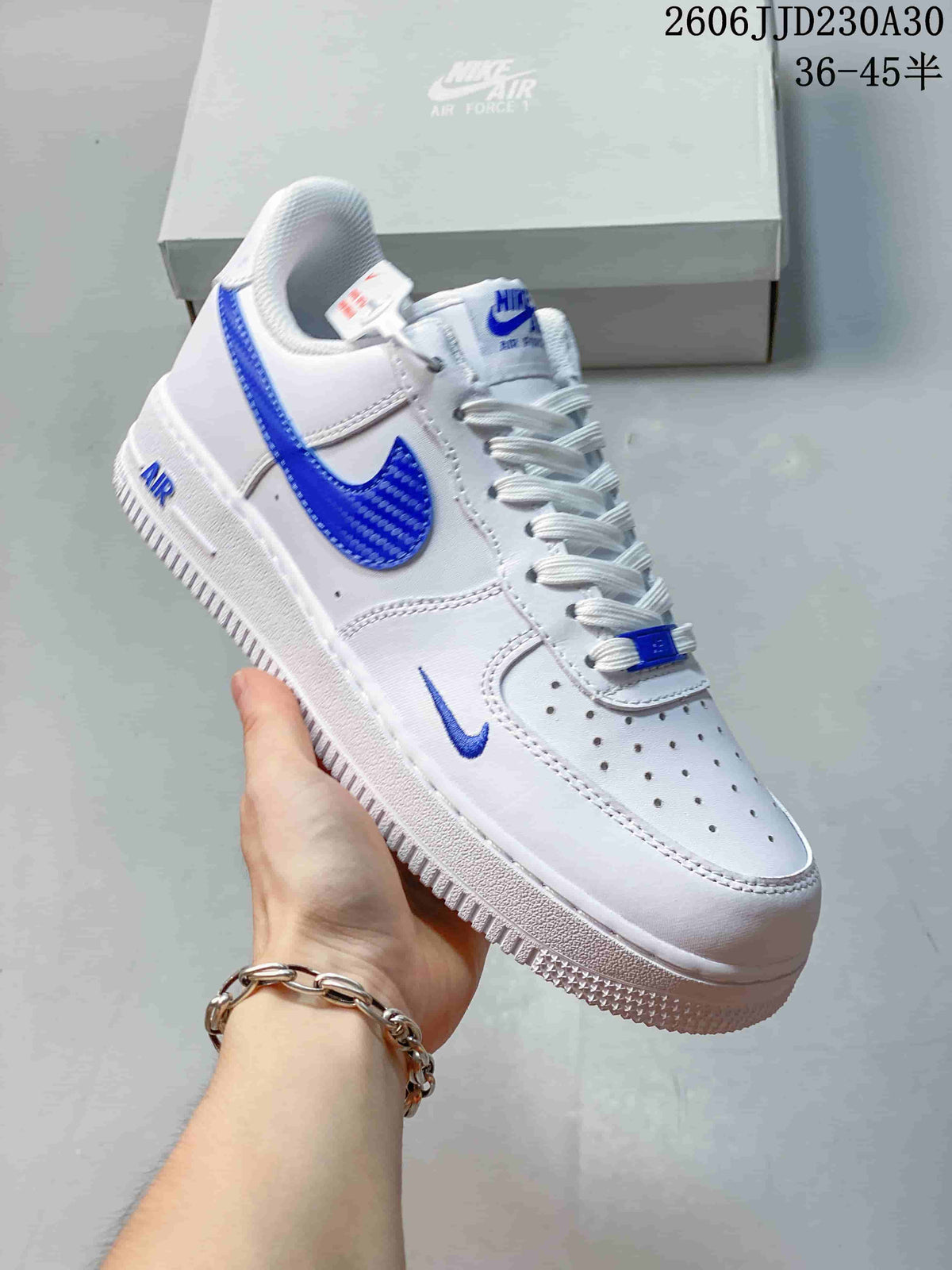 Angled view of a white low-top sneaker with blue Swoosh details
