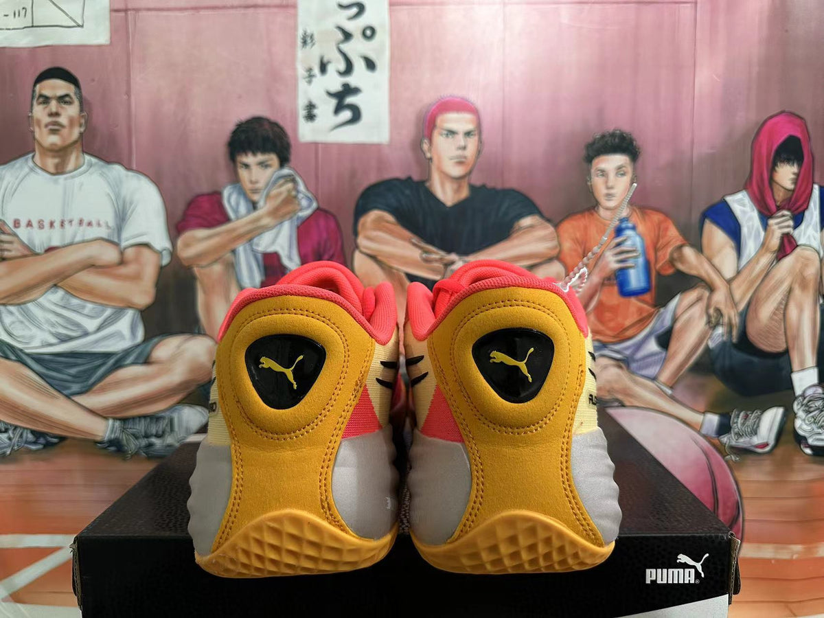 Rear view of coral pink and gold PUMA All-Pro basketball shoes on a black shoebox.