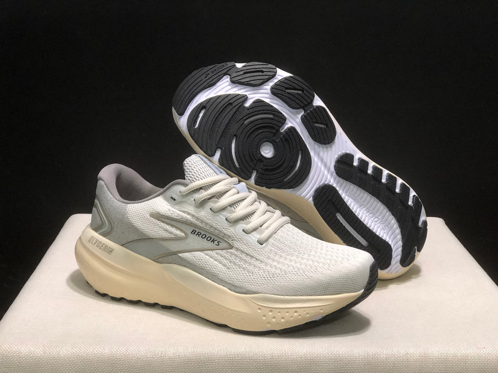 Angled view of the sneakers with one shoe lifted to show the black-and-white outsole pattern.