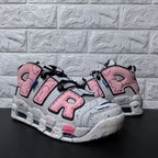 Pair of pink and grey Nike sneakers shown from a front three-quarter angle