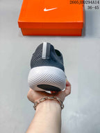 Rear view of a dark gray Nike Free sneaker showing the heel pull tab, textured upper, and white sculpted sole.