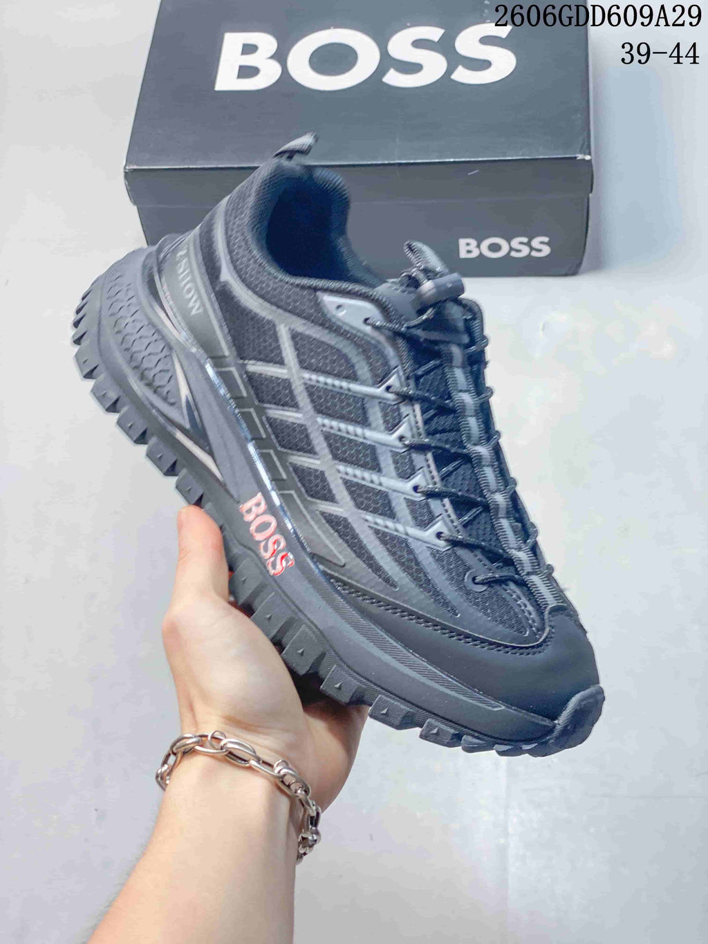 Angled side view of the gray BOSS sneaker with panel detailing and rugged outsole.