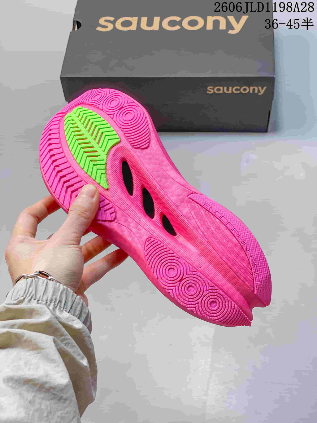 Bright pink outsole with green traction section on a Saucony running shoe