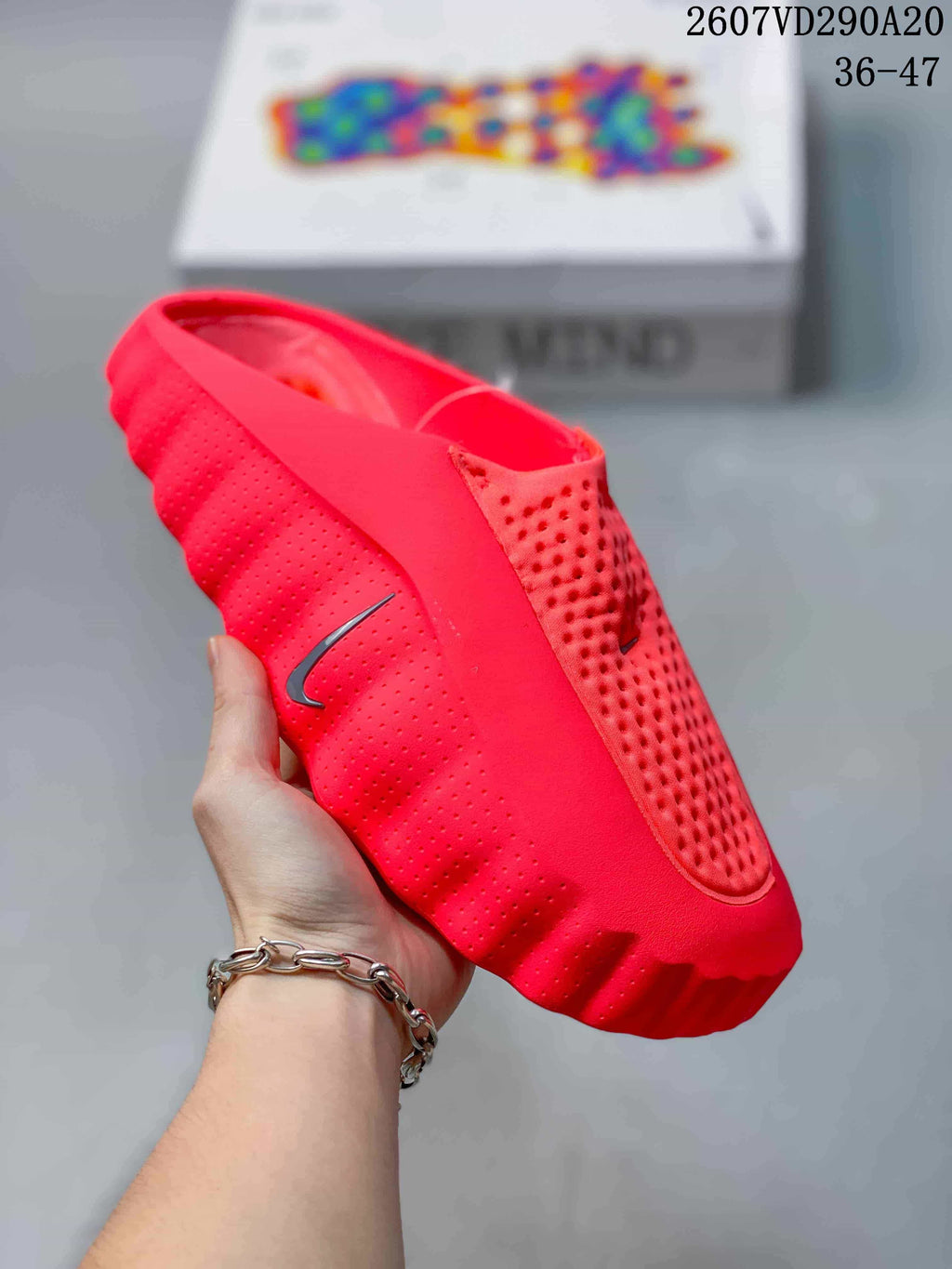 Close side view of a red Nike Mind 001 slide showing perforated side panels and a sculpted outsole.