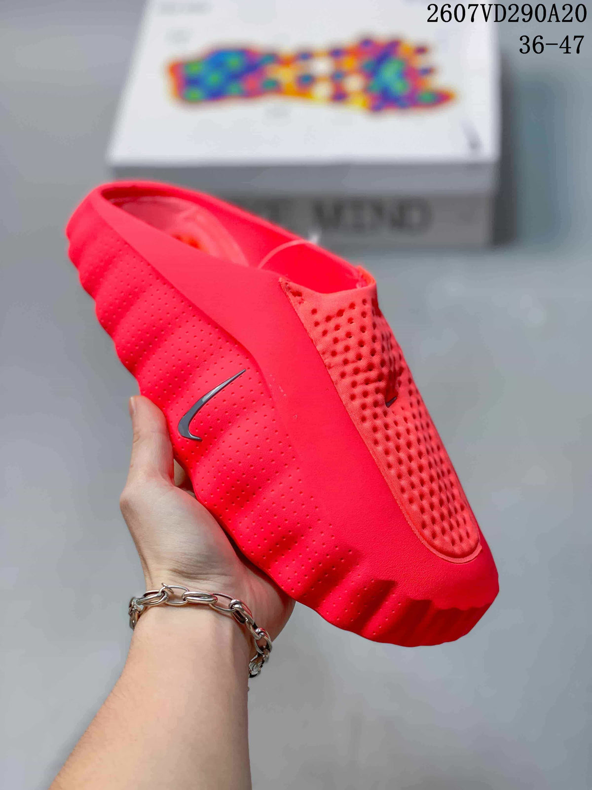 Close side view of a red Nike Mind 001 slide showing perforated side panels and a sculpted outsole.