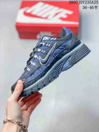 Side view of a blue and dark gray Nike P-6000 sneaker showing mesh panels, layered overlays, side swoosh and ridged midsole.