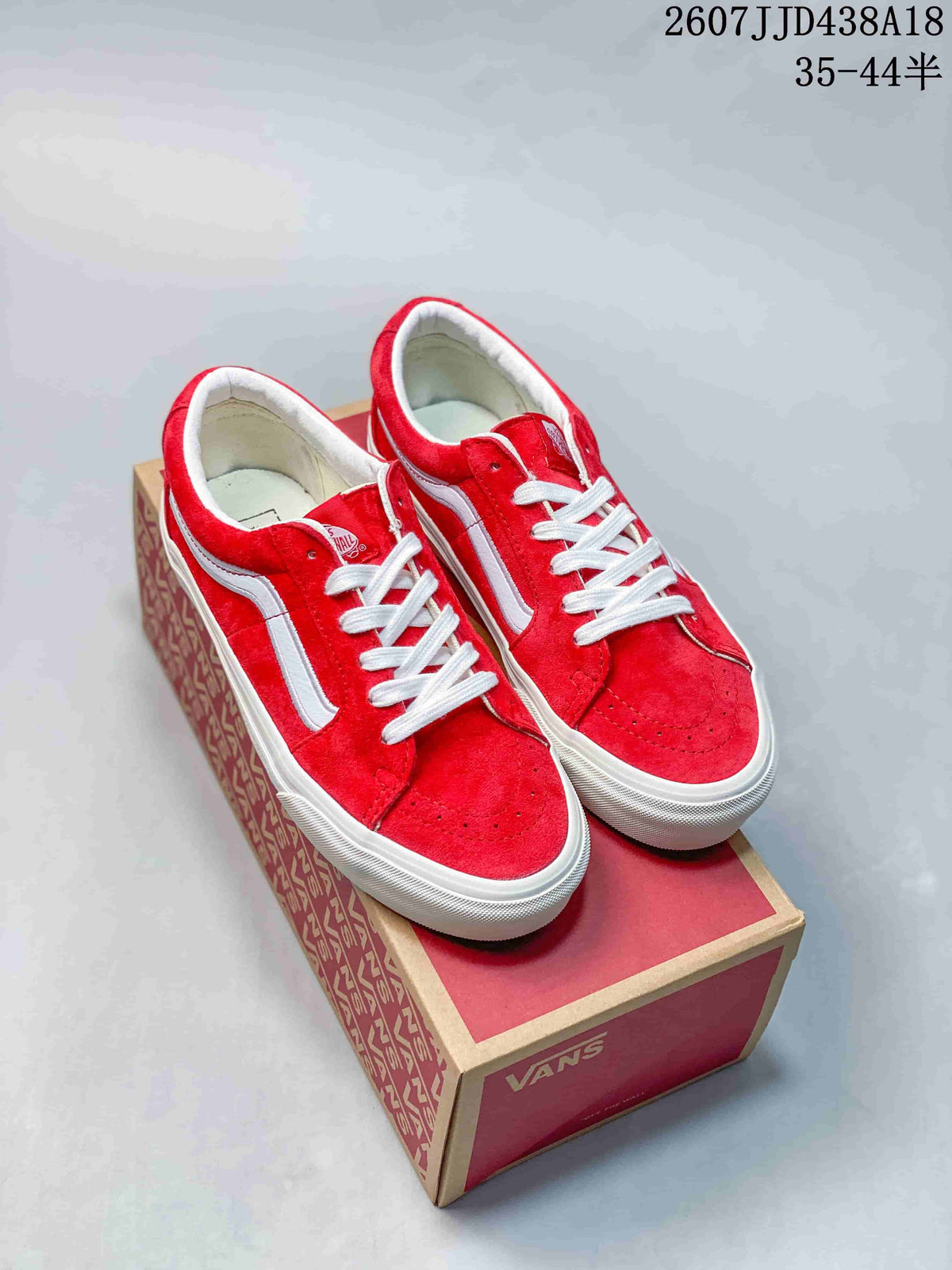 Pair of red and white Vans low-top sneakers displayed on a branded shoe box.