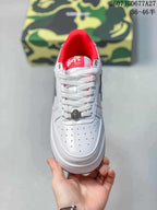 Top view of a white BAPE Sta sneaker showing the perforated toe box, white laces, tongue branding and metallic lace accessory.