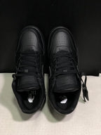 Top view of the black sneaker pair showing perforated toe boxes, tonal laces and branded-style insole graphics.