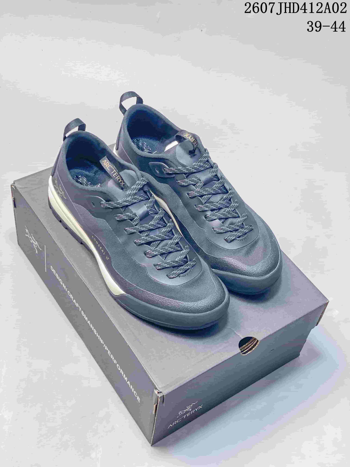 Pair of slate gray Arc'teryx KONSEAL LT W shoes on a branded box