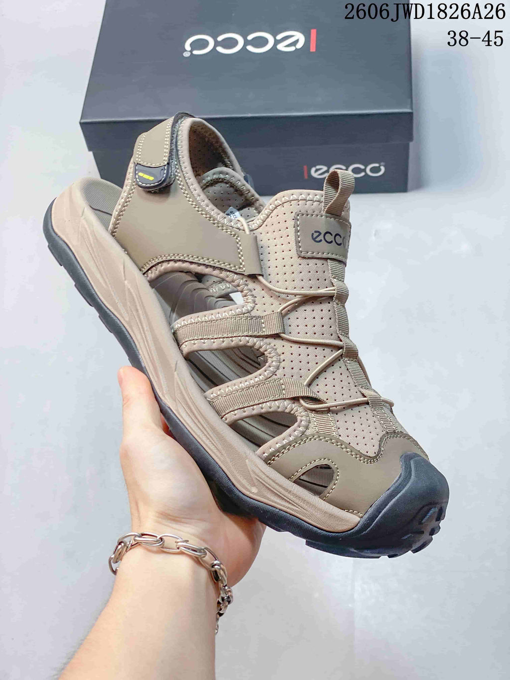 Close-up of a beige open-toe sandal with perforated panels, bungee lacing, heel strap, and toe bumper.