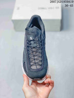 Front view of the black sneaker showing the mesh tongue, lace system, rounded toe, and white outsole edge.