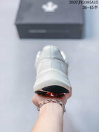 Rear view of the white sneaker showing the padded heel collar, layered heel structure and dark outsole edge.