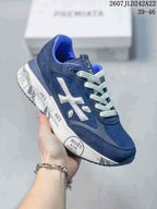 Angled side view of the navy blue Premiata trainer with white laces, contrasting logo and graphic white midsole.