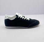 Lateral view showing the black sneaker upper, white heel detail, and textured outsole.