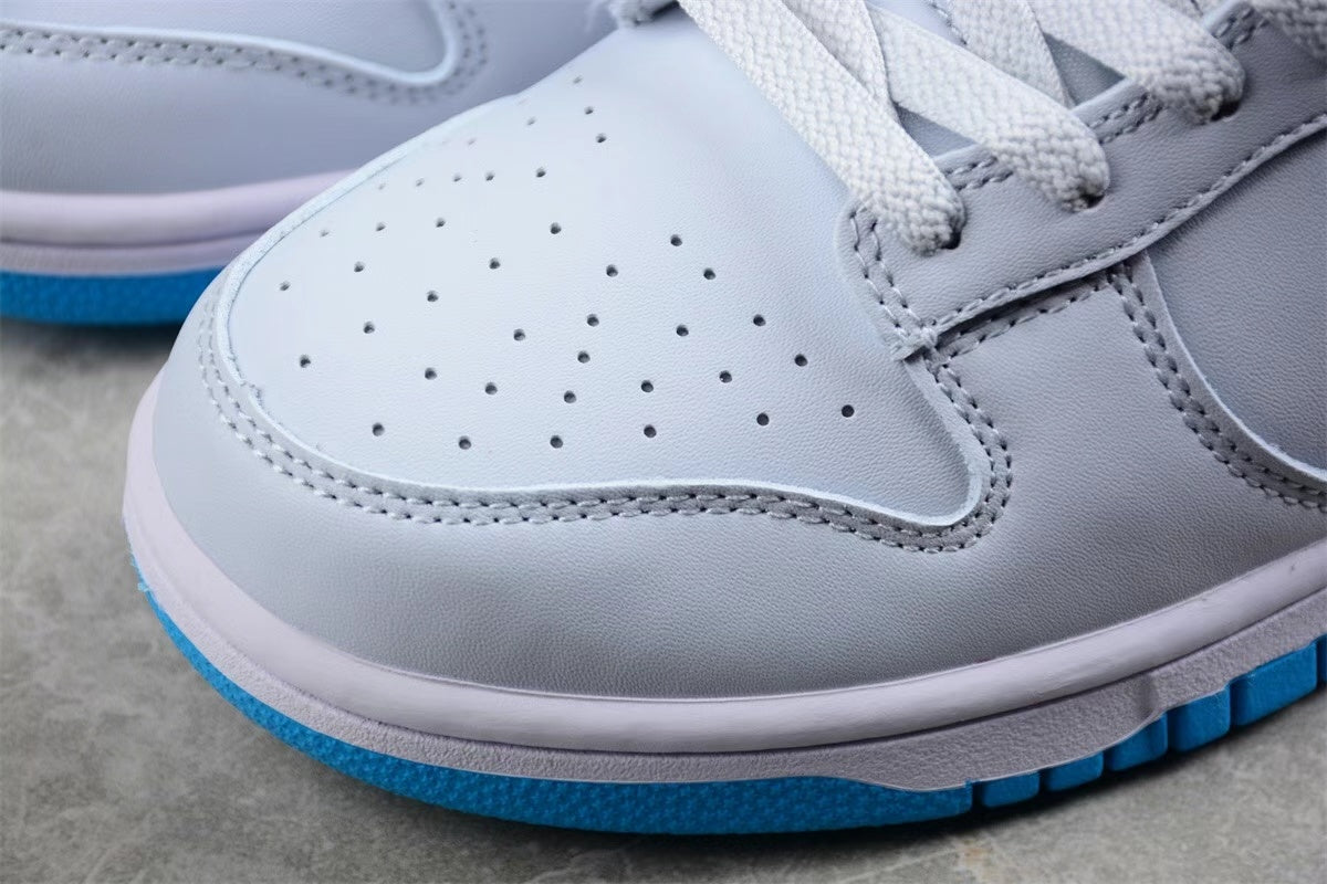 Close-up of the perforated light-colored toe box, gray overlay, white midsole, and blue outsole edge.