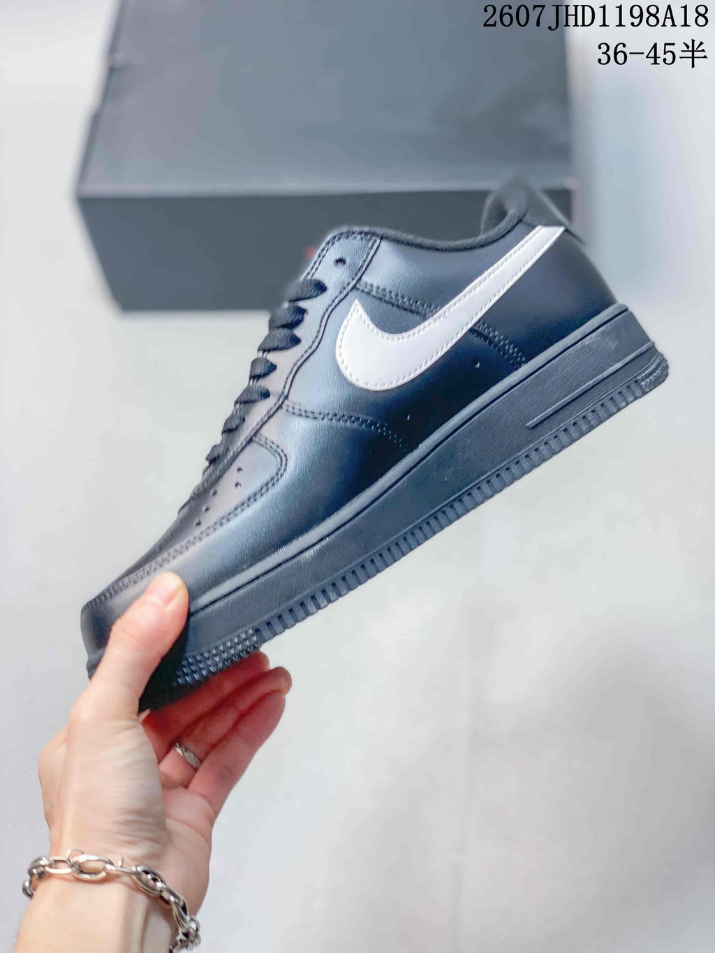 Side view of a black low-top sneaker with a contrasting white Swoosh, perforated upper panels, and textured outsole; image text shows style code 2607JHD1198A18 and sizes 36–45.5.