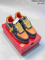 Pair of navy and orange low-top sneakers with gold-tone accents and a horse charm.