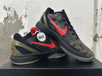 Two Nike Kobe shoes displayed together, showing the red Swoosh and camouflage-patterned upper.