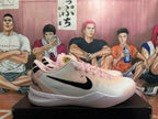Side view of a pink Nike sneaker showing the black Swoosh, pale upper and white sole.