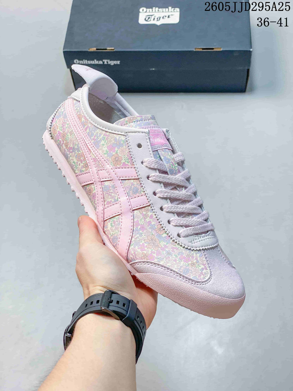 Close side view of a pink floral Onitsuka Tiger sneaker showing its lace-up front, side stripes and textured outsole.
