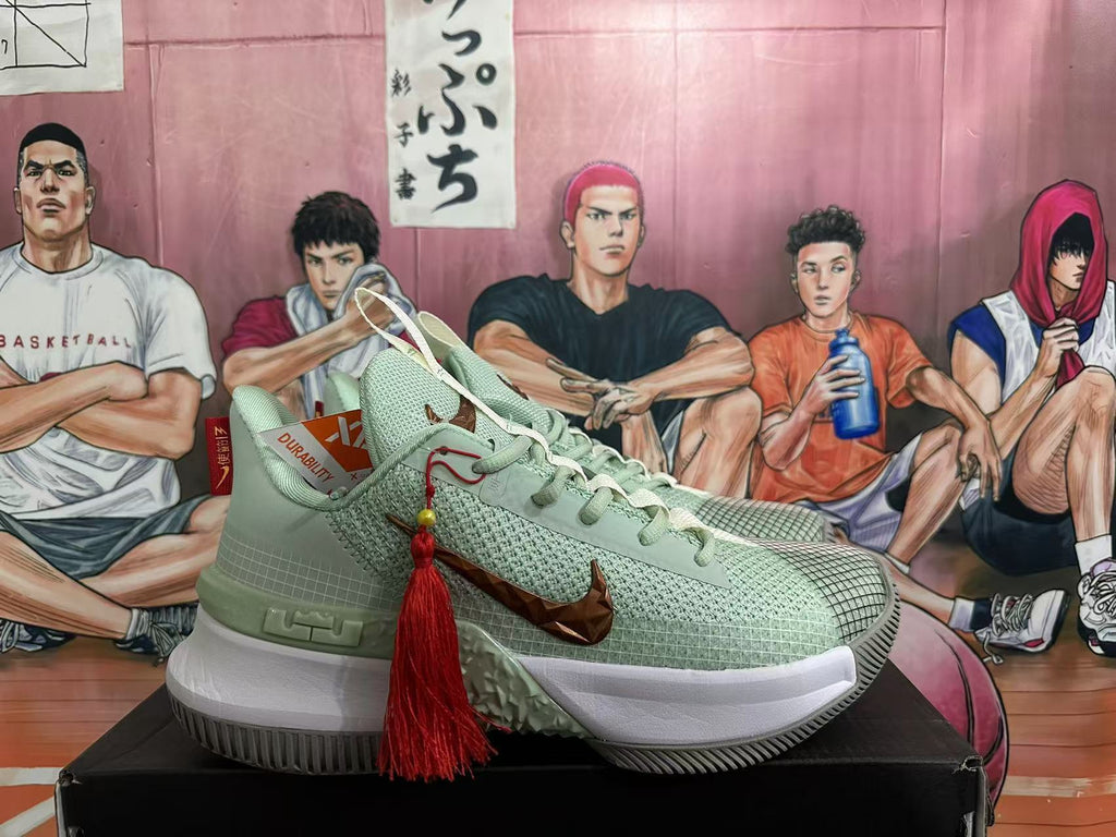 Side view of a jade green Nike sneaker with bronze-toned Swoosh detailing, white midsole, textured outsole, and red tassel accessory.