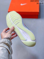 Close-up of the translucent outsole and ribbed tread pattern on a white running shoe.