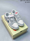 Pair of gray and white low-top sneakers with dark Swoosh details, patterned laces, and a light-colored shoe box.