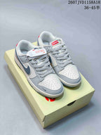 Pair of gray and white low-top sneakers with dark Swoosh details, patterned laces, and a light-colored shoe box.