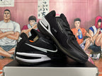 Angled view of black basketball shoes with white side and heel accents