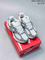 Pair of white and grey Nike V5 RNR sneakers displayed on a red shoebox, with style text and size range visible above.