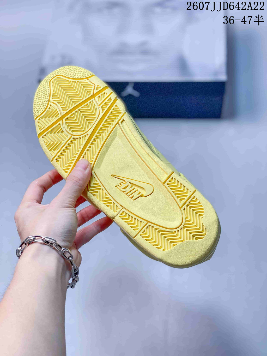Bottom view of the yellow sneaker showing the textured rubber outsole and central Nike branding.