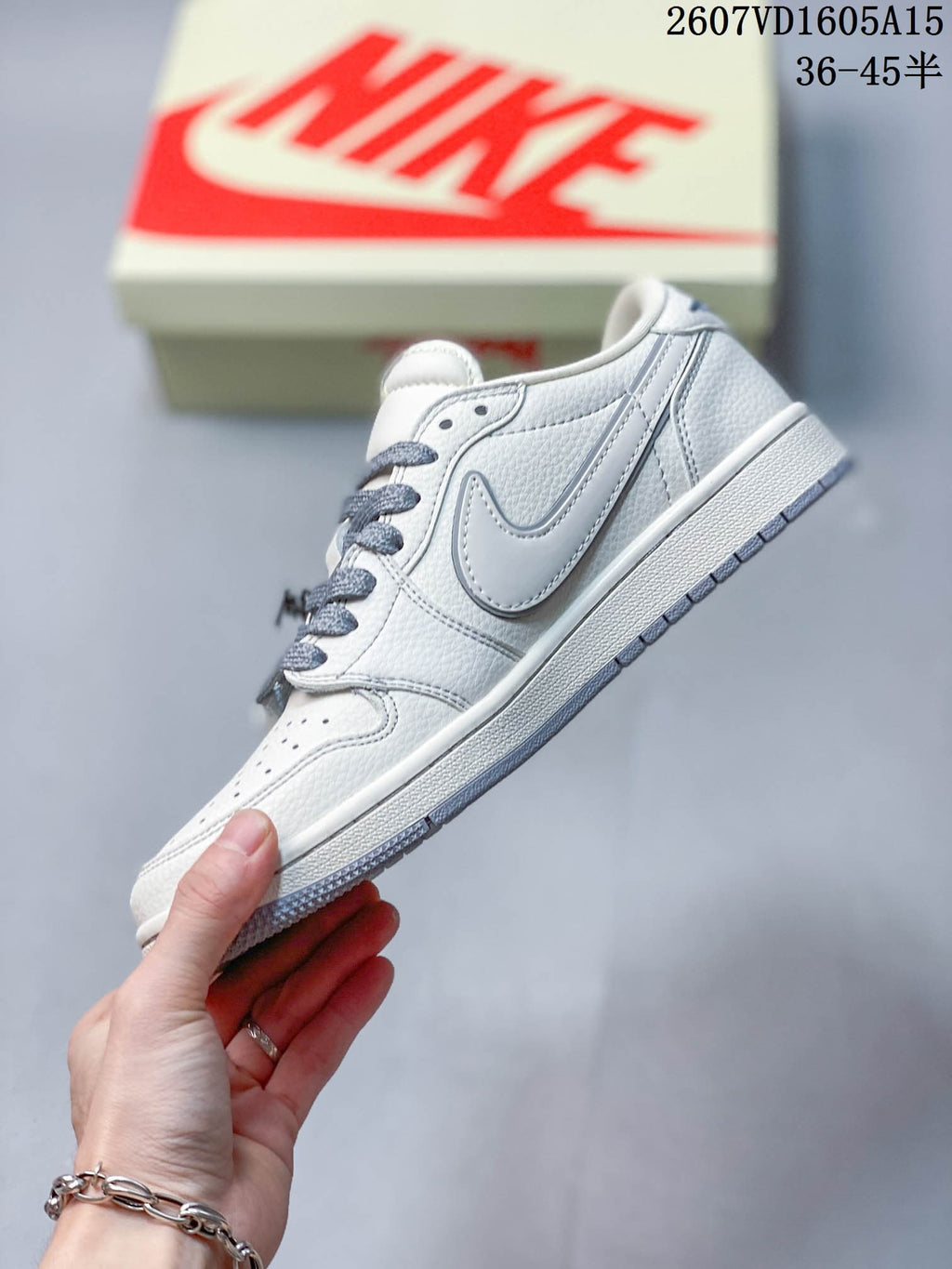 Side view showing the white low-top profile, light gray Swoosh, stitched panels, and gray outsole.