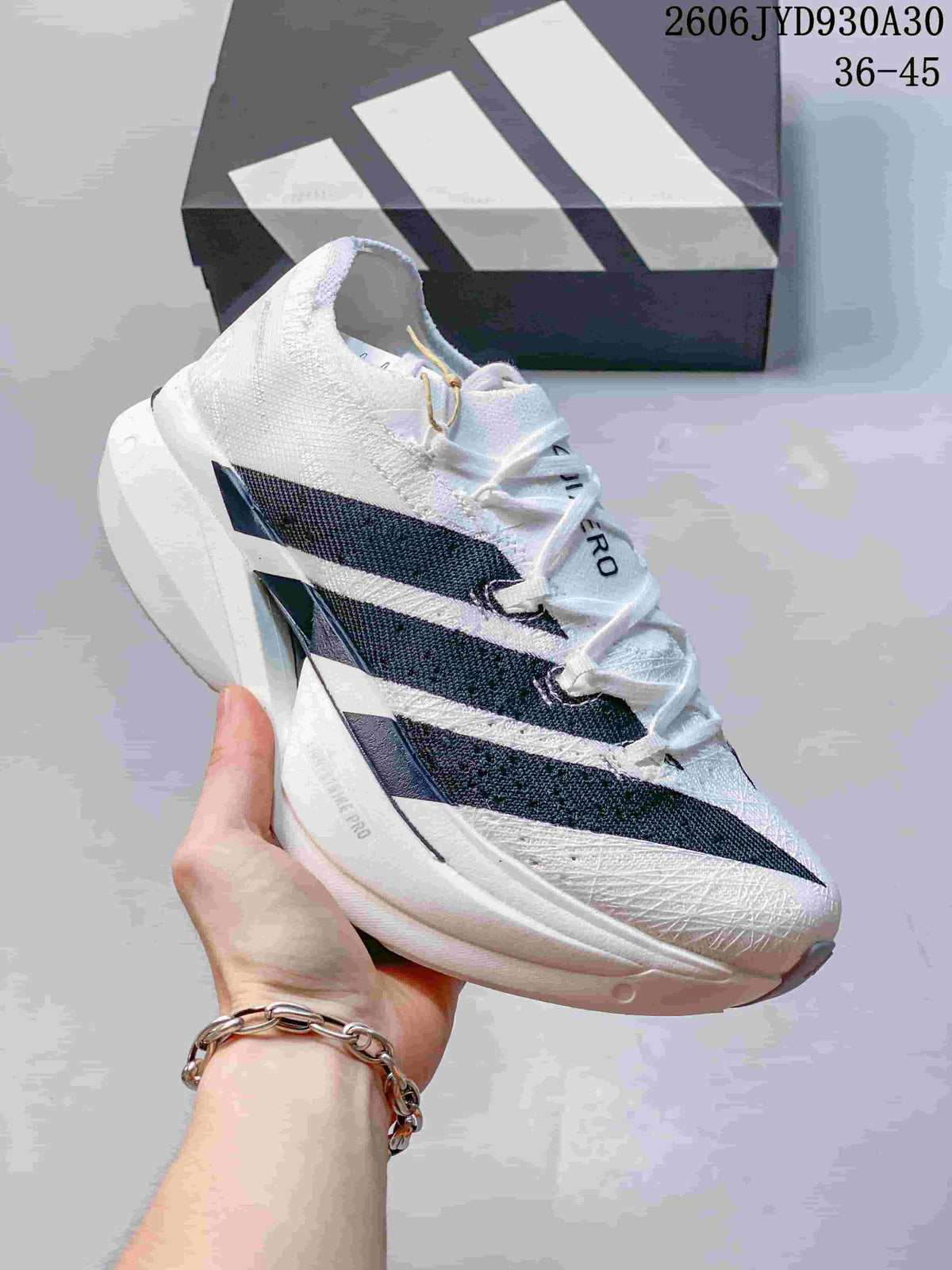 Angled side view of a white adidas Adizero Prime X3 running shoe with dark stripes.