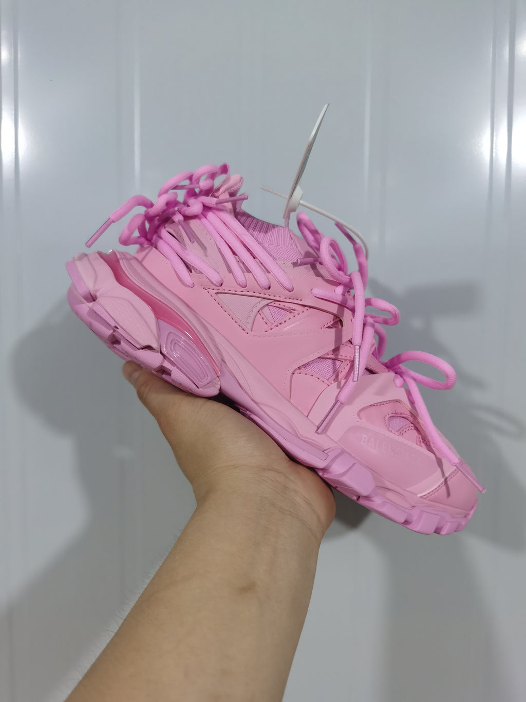 Angled view of the pink Balenciaga sneaker highlighting the layered side panels, lace details and sculpted sole.