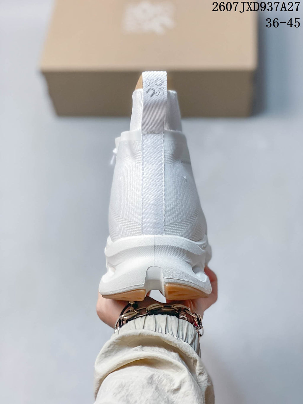 Rear view of the white high-top sneaker showing the collar, heel pull tab, and segmented outsole.
