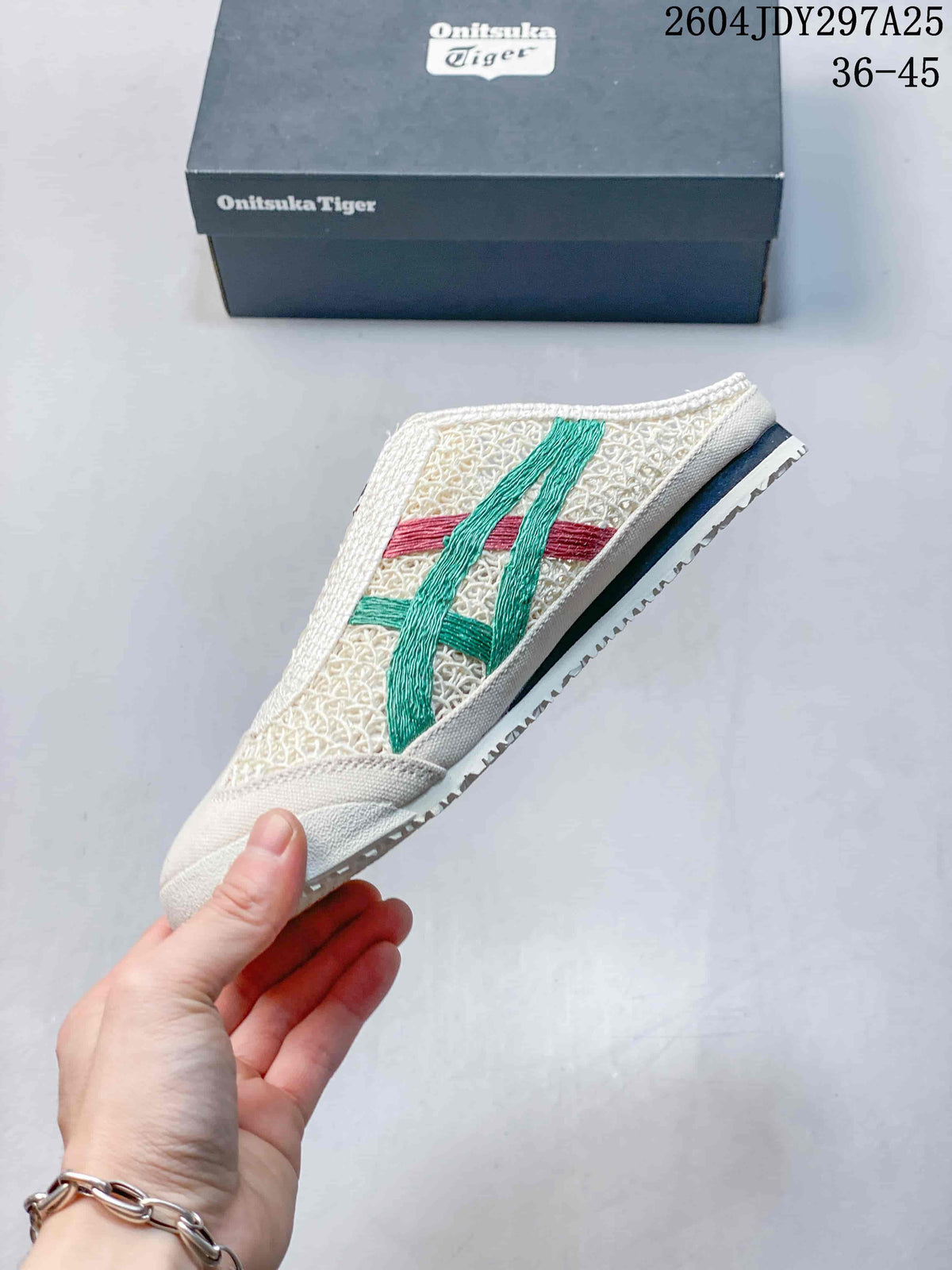 Side profile of the Mexico 66 Sabot sneaker showing the cream upper, green and red stripes, open heel, and textured outsole.