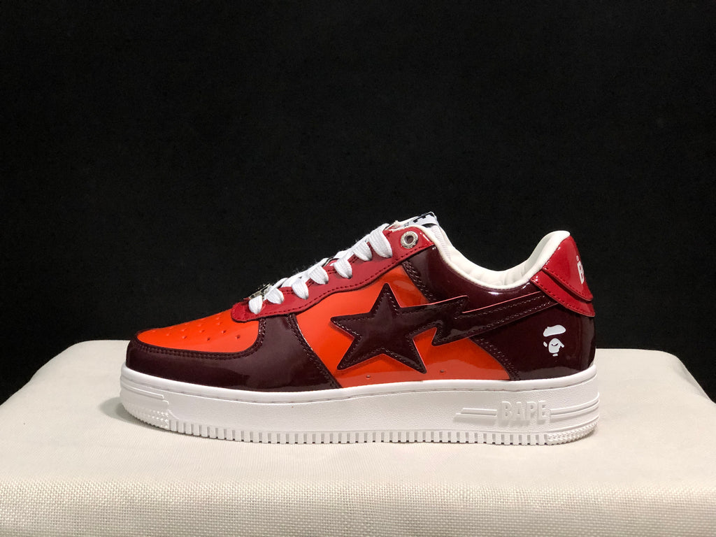 Side view showing the glossy burgundy and orange upper, large star-shaped side detail and white sole.