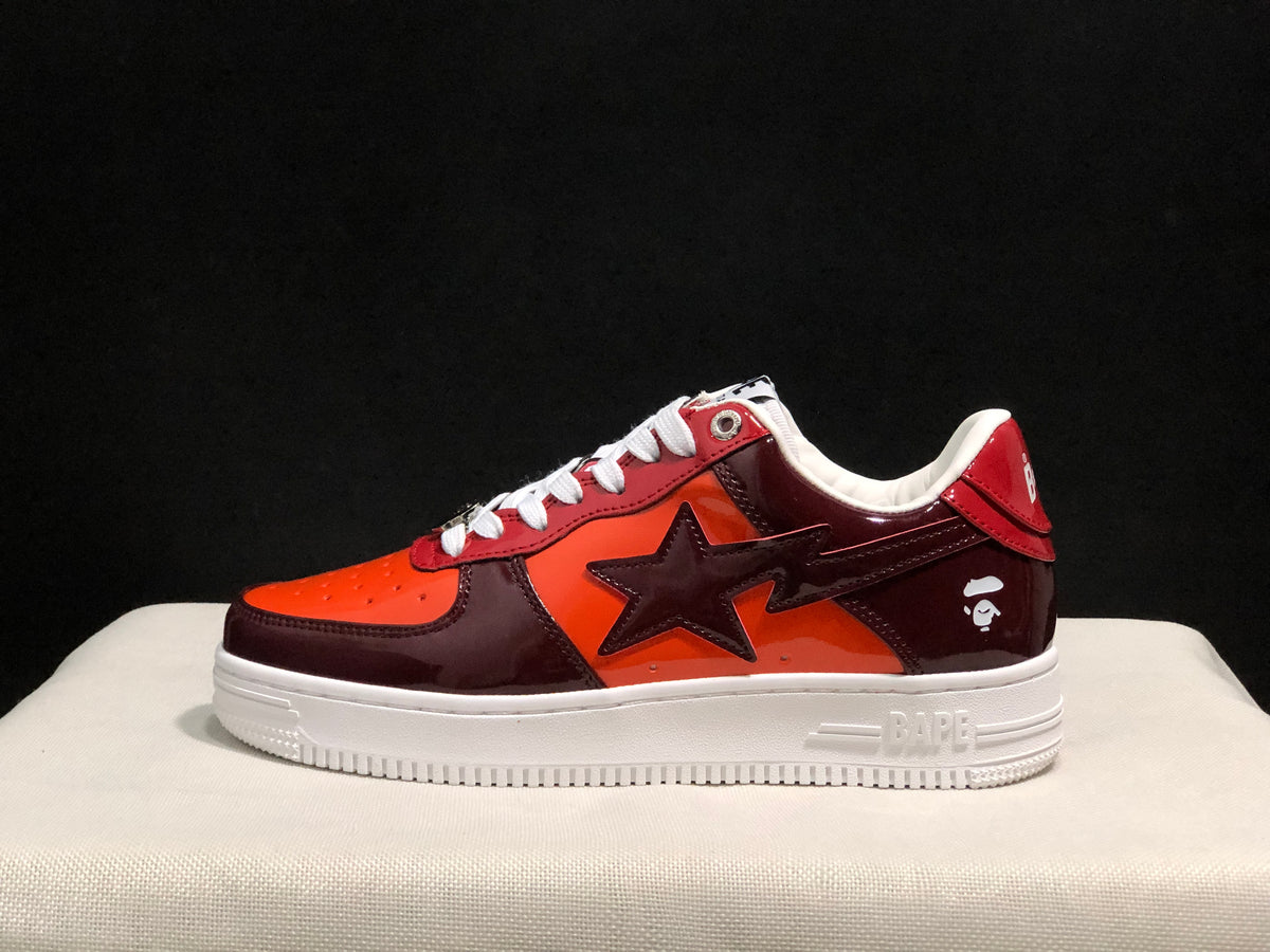 Side view showing the glossy burgundy and orange upper, large star-shaped side detail and white sole.