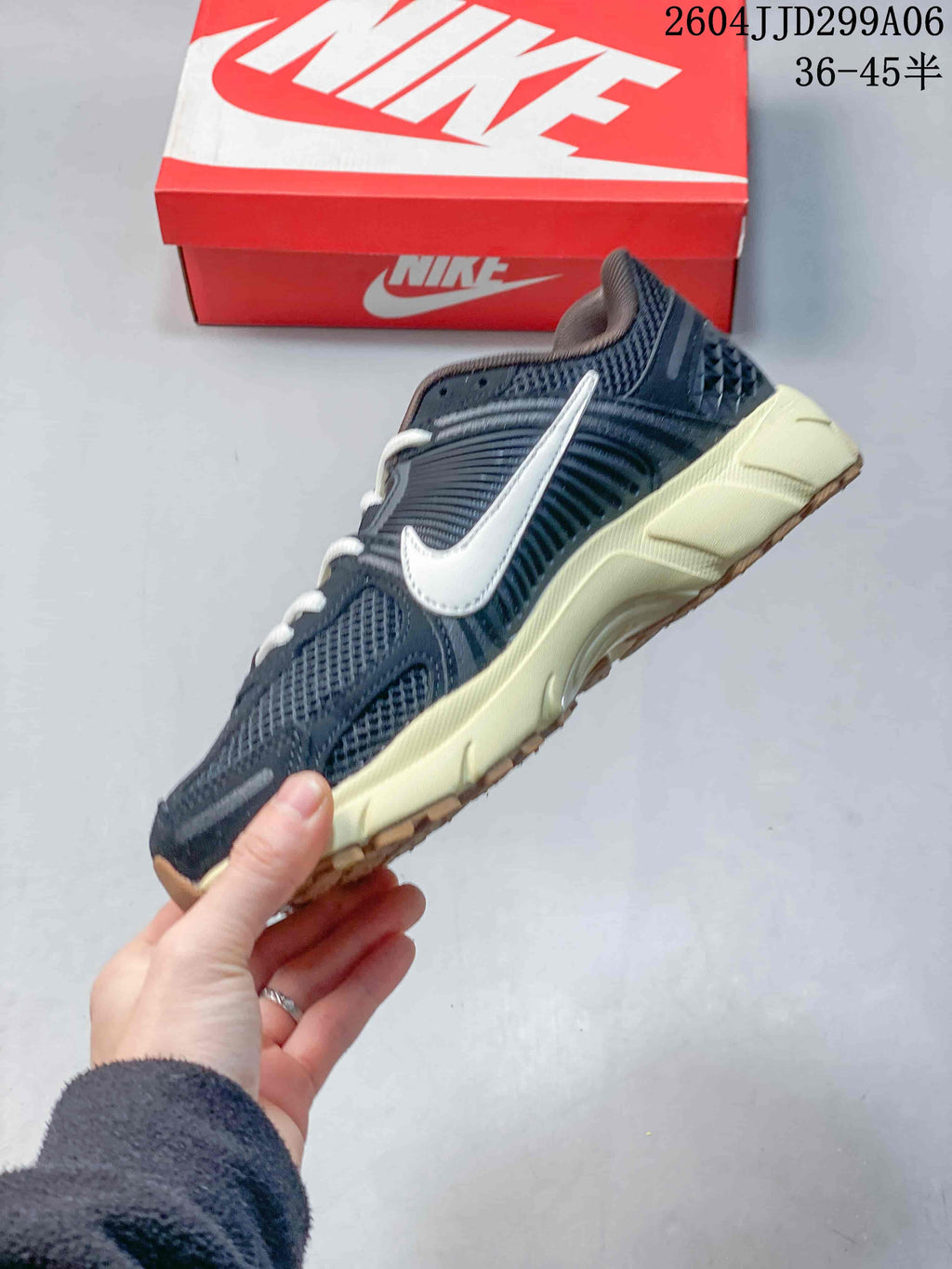 Side profile of the navy sneaker showing layered panels, mesh sections, white Swoosh branding, and an off-white midsole.