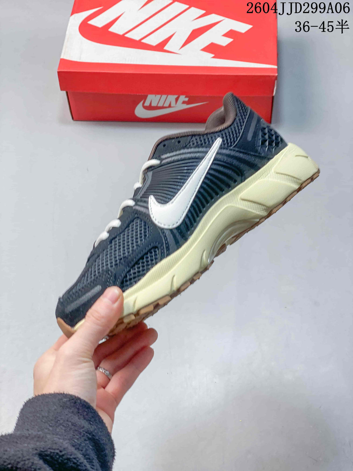 Side profile of the navy sneaker showing layered panels, mesh sections, white Swoosh branding, and an off-white midsole.