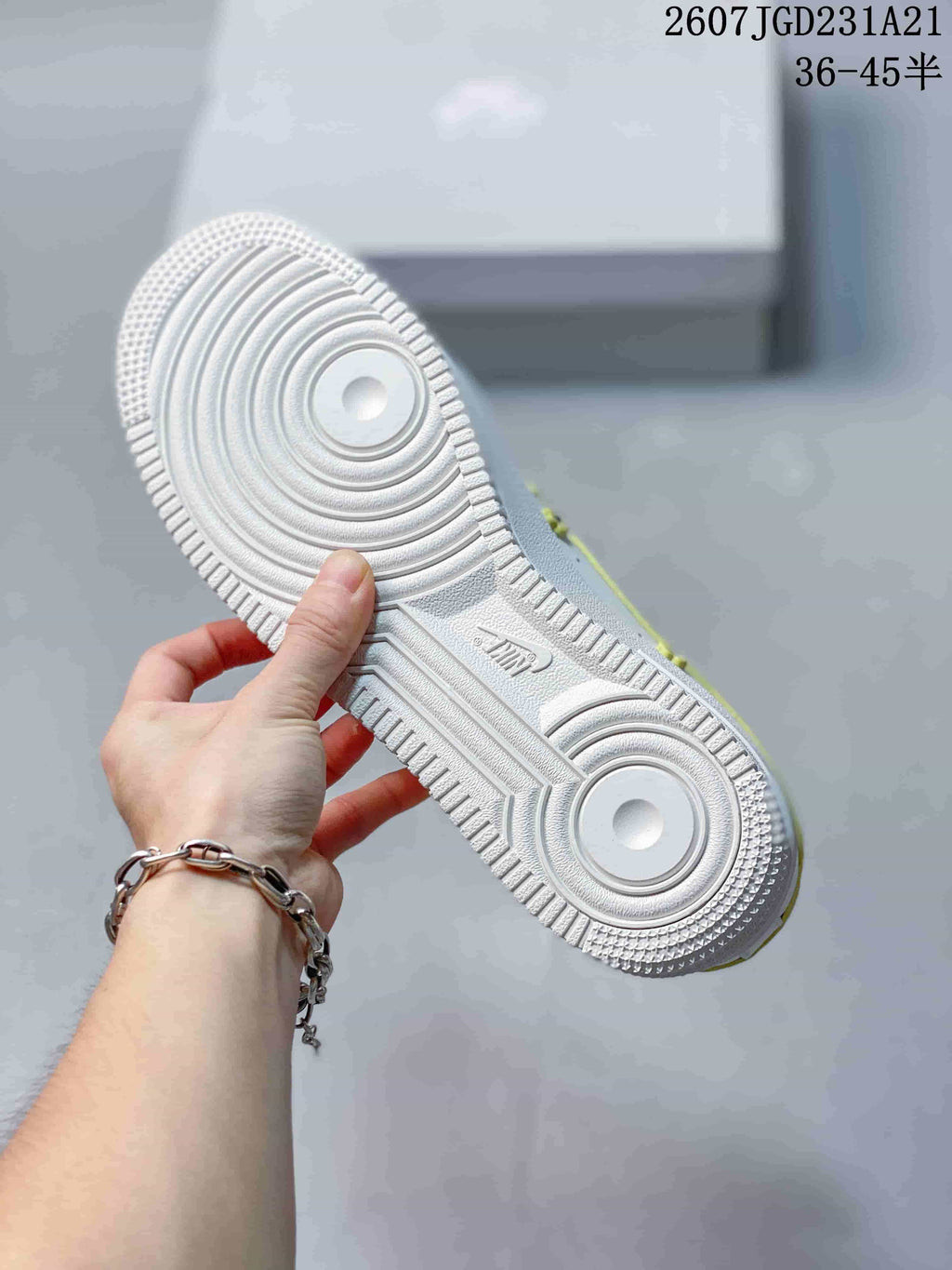 Close view of the white textured rubber outsole with circular traction patterns and molded branding.