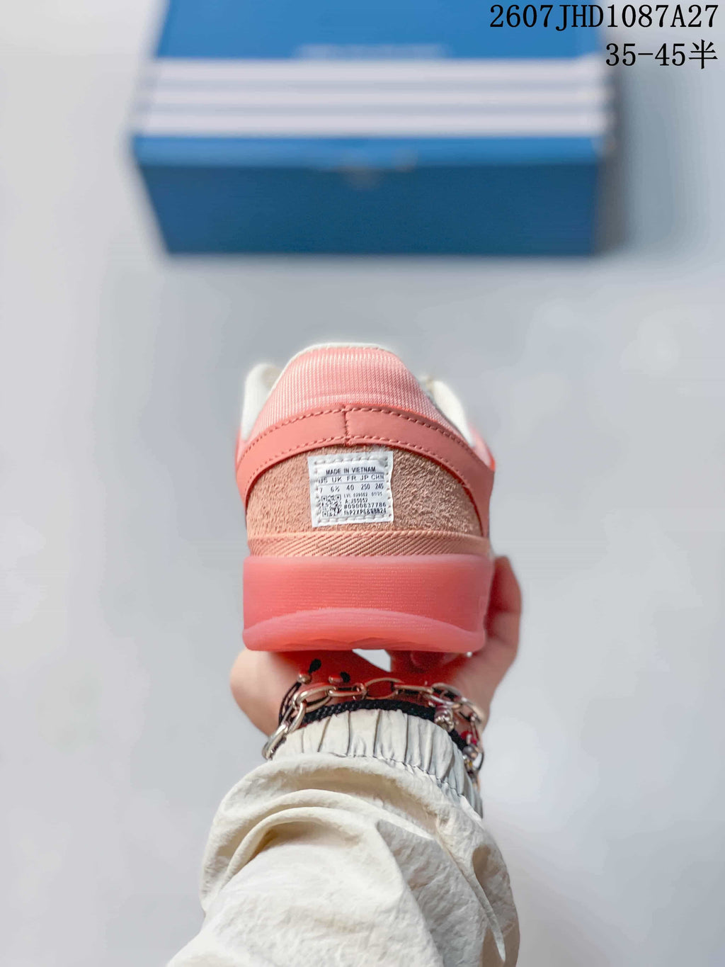 Rear view of the pink sneaker showing the padded heel and visible shoe label.