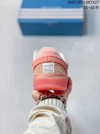 Rear view of the pink sneaker showing the padded heel and visible shoe label.